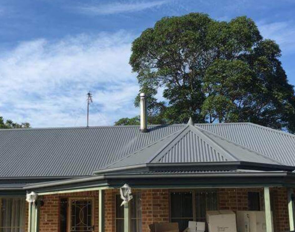 Restored metal roof on a Brisbane home against a clear sky
